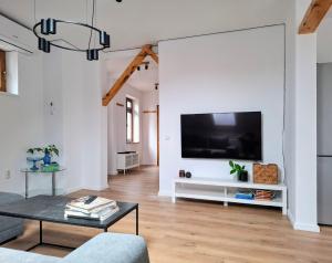 a living room with a large tv on a white wall at Casa de pe colț in Orăştie