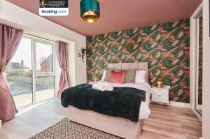a bedroom with a large bed with a floral wallpaper at Luxurious 4Bedroom House By Homebird Property Management Short Lets & Serviced Accommodation Leeds With Private Parking, Garden & Patio Area in Leeds