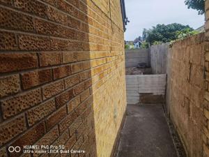 an alley with a brick wall next to a building at Wellesley Apartments in Great Clacton