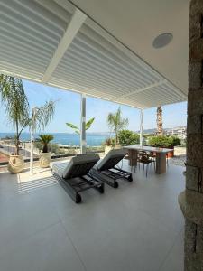 a patio with two lounge chairs and a table at Nava Sol Apartment in Vlorë