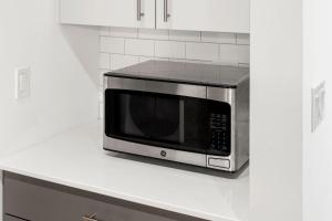 a microwave sitting on top of a kitchen counter at City Studio Escape Bright Sleek & Modern in Chicago