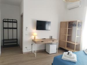 a room with a desk and a tv on a wall at MareLaghi b&b in Messina