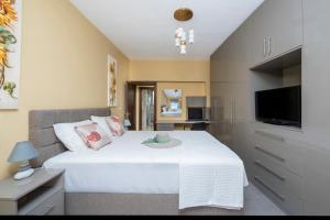 Un dormitorio con una gran cama blanca y un televisor. en Magical House, en Ialisos