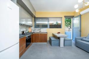 una cocina con una mesa y un sofá azul en Magical House, en Ialisos