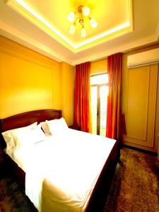 a bedroom with a bed with white sheets and a window at Boulevard Tashkent City 02 in Tashkent