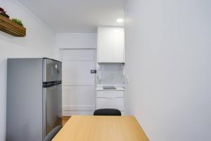 a kitchen with a wooden table and a refrigerator at Compact Chiado Spacious and Exceptional in Lisbon in Lisbon