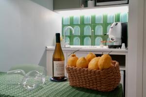 a basket of pears and a bottle of wine on a table at Villa Emma Exclusive in Vico Equense