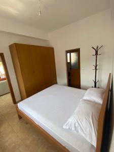 a bedroom with a large bed with white sheets at Delvina Penthouse in Delvinë