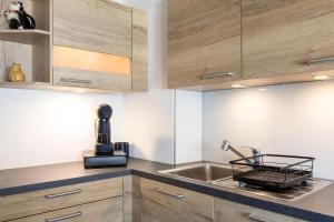 a kitchen with wooden cabinets and a sink at Apartment "Haus Edelweiss" in Scharnitz