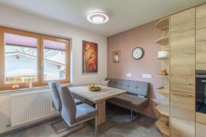 a dining room with a table and chairs and a clock at Apartment "Haus Edelweiss" in Scharnitz +55 photos