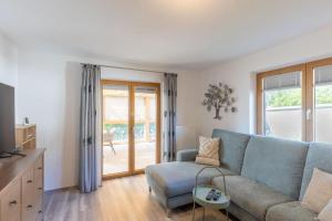 a living room with a blue couch and a table at Apartment "Haus Edelweiss" in Scharnitz