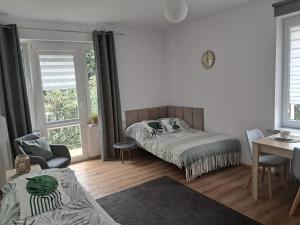 Un dormitorio con una cama y una mesa y sillas. en Apartament VERDE Malbork centrum, en Malbork