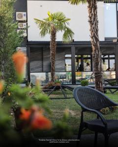 a patio with a chair and palm trees in front of a building at Kompleksi Endeta in Bathore