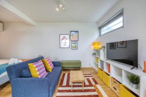 un salon avec un canapé bleu et une télévision dans l'établissement Garden & Central - Near United Nation - Geneva - CERN, à Ferney-Voltaire 17 autres photos