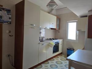 a kitchen with a white refrigerator and a stove at Attico vista mare in centro in Gallipoli