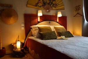 a bedroom with a large bed with two pillows at Suivez Le Lapin Blanc-BB Chambres d'Hôtes in Saint-Valery-sur-Somme