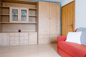 a living room with a red couch and wooden cabinets at Ciasa Silvano 1721 SV in Falcade