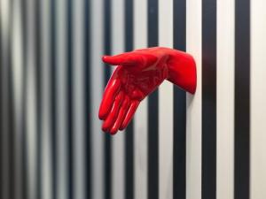 a red latex glove hanging from a metal wall at Suivez Le Lapin Blanc-BB Chambres d'Hôtes in Saint-Valery-sur-Somme