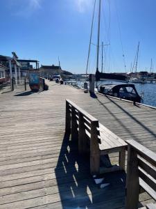 a wooden dock with a bench on the water at Strand 18b in Grebbestad +20 photos