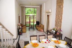 uma sala de jantar com mesa e cadeiras e uma sala de estar em Hermitage Suites Koregaon Park em Pune