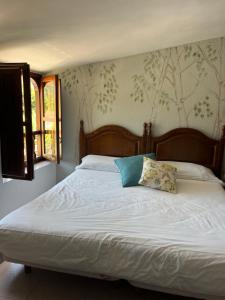 a bed with a pillow on it in a bedroom at El pucheru 4 Almas in Barcenaciones