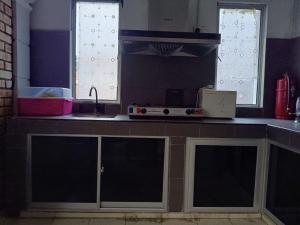 a kitchen with a counter top with a sink and a counter top at Ateh's Homestay KLIA1 in Sepang +6 photos
