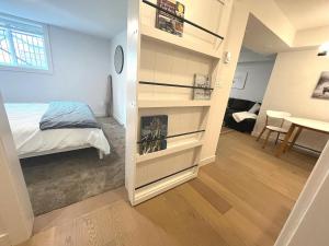 a bedroom with a book shelf next to a bed at Cedar & Sage Suite, Cozy Kitchen Comfort in Victoria
