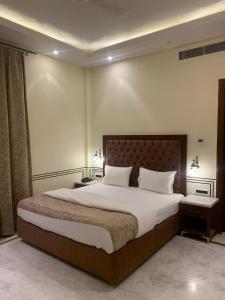 a bedroom with a large bed with white sheets and pillows at Hotel Anand Bagh -Eraya Hotels in Phulera