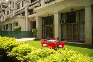 uma mesa e cadeiras em frente a um edifício em Hermitage Suites Koregaon Park em Pune