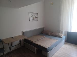 a small bedroom with a bed and a table at Loft House Budapest in Budapest
