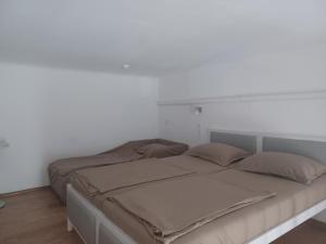 a bed in a bedroom with a white wall at Loft House Budapest in Budapest