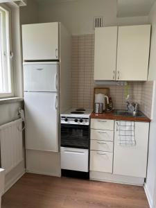 une cuisine avec des appareils électroménagers blancs et des armoires blanches dans l'établissement Studio Apartment, à Rovaniemi