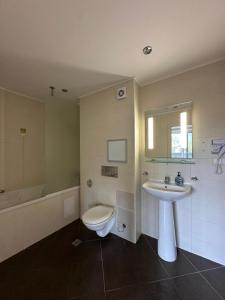 a bathroom with a sink and a toilet and a tub at Приказна гледка B5 2 in Borovets