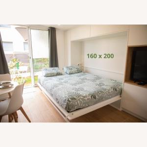 VarreddesにあるRez de Jardin - Calme & Familialeのベッド、テレビ、テーブルのある寝室