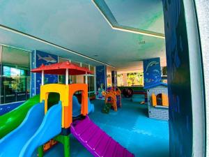 a play room with a slide and a playground at Apartamento com piscina a poucos passos da praia in Niterói