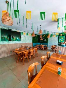 a restaurant with wooden tables and chairs and lights at Apartamento com piscina a poucos passos da praia in Niterói