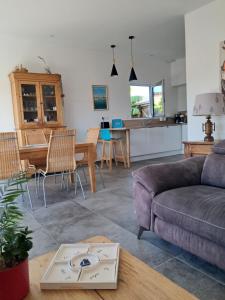 a living room with a couch and a table at Séjour cosy proche mer- la Torche- spot surf in Penmarcʼh +30 photos