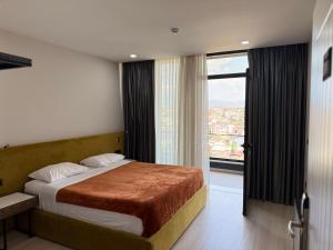 a bedroom with a bed and a large window at Kompleksi Endeta in Bathore