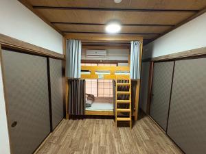 a room with two bunk beds and a ladder at 木の家ゲストハウス前橋3号館 in Maebashi