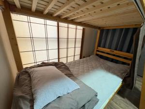a small bed in a room with a window at 木の家ゲストハウス前橋3号館 in Maebashi +6 photos