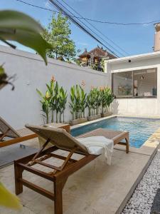 Una piscina con una tumbona y una casa. en Tranquil 2BR Villa with Pool, en Kerobokan