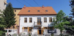 a large white house with a red roof at Casa de pe colț in Orăştie