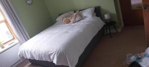 a bed with white sheets and pillows in a bedroom at Apartment above Sweetharts bakery and coffeeshop in Blackhill, Durham in Shotley Bridge