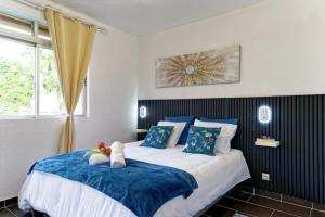 um quarto com duas camas com almofadas azuis e brancas em Appartement confortable à Sainte-Luce 50 m² avec terrasse em Sainte-Luce