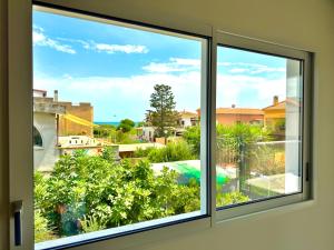 a window with a view of a garden at Blu Mare Casa Vacanza in La Maddalena