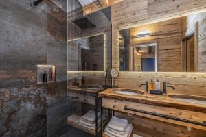 een badkamer met twee wastafels en een glazen douche bij Boutique Hotel e Chalets Salvadori in Mezzana