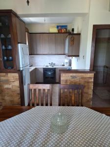 a kitchen with wooden cabinets and a table with a table at Villa Aigani,maisonette, Kato Olympus, Sunrise View in Aigáni +22 photos