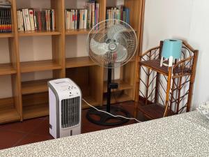 - un ventilateur dans une chambre à côté d'une étagère dans l'établissement SediciBis, à Bologne