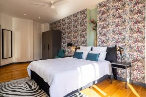 1 dormitorio con 1 cama blanca grande y un mural en la pared en Capitole Horizon, en Toulouse