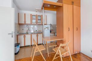 a kitchen with a table and chairs and a refrigerator at Apartman Zvezda in Igalo